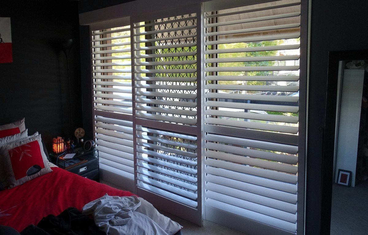 White plantation shutters installed on a window, allowing light to filter into the room.