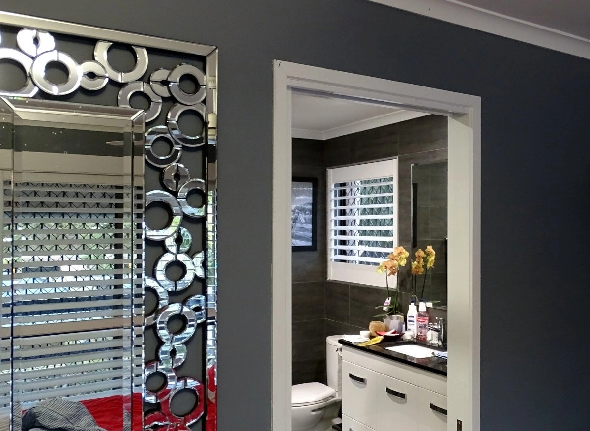 Interior view of a bathroom featuring a decorative mirror and modern fixtures.