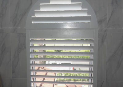 Flush style plantation shutter for arched window in bathroom